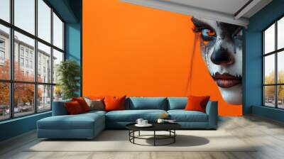 Portrait of a young woman with a Halloween makeup on a orange background.  Wall mural