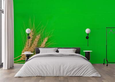 Green wooden background with three wheat ears Wall mural