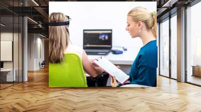 Young teenage girl and child therapist during EEG neurofeedback session. Electroencephalography concept. Wall mural