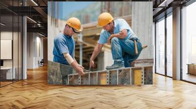 two construction workers installing concrete formwork frames Wall mural