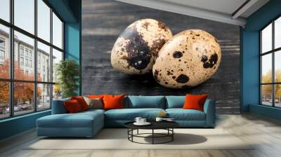 Two raw quail eggs on dark wooden background Wall mural