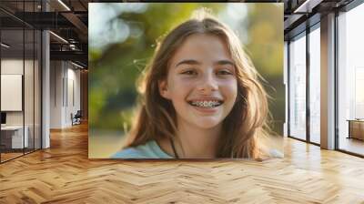 A girl with braces is smiling and looking at the camera Wall mural