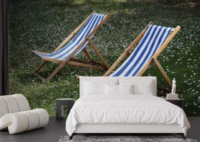 two sun loungers in the garden, on green grass with daisies Wall mural