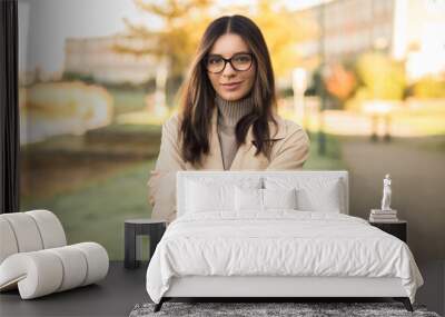 Beautiful LGTB student woman 20s with glasses in the street confidently and profoundly looking towards the camera Wall mural