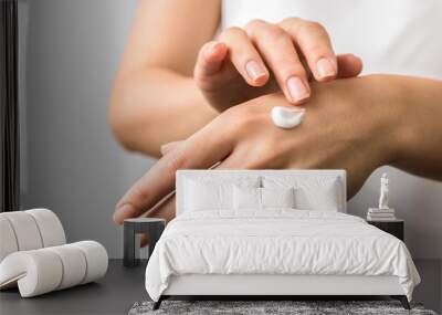 closeup of tender hands of a young woman with moisturizer on. spring skin protection Wall mural