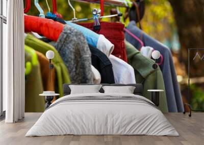 Hangers with men's and women's clothing at the garage sale Wall mural