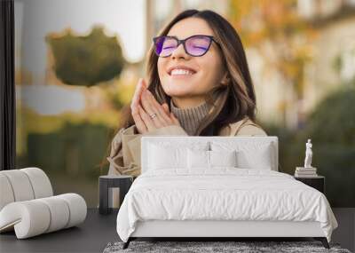 Improved vision performance. Beautiful woman 20-30s wearing glasses with cheerful smile in the street Wall mural