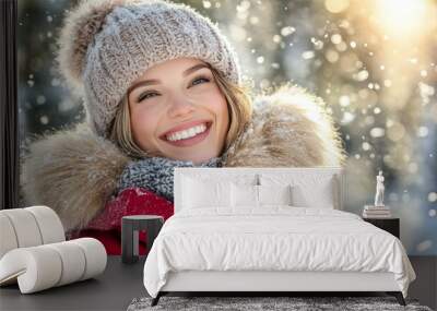 Joyful young woman in a red winter coat enjoys magic of snowfall on a sunny winter day. Wall mural