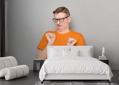 Portrait of blond mature man wincing and grimacing from disgust Wall mural