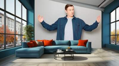 Portrait of impressed mature man showing large size of something Wall mural