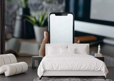 Mobile phone mockup with blank screen in female hand. Office desk in the background Wall mural