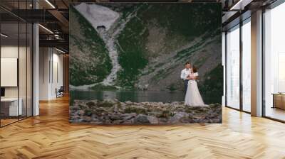 Portrait of a young beautiful couple. Hug each other against the backdrop of a mountain lake. Copy space Wall mural