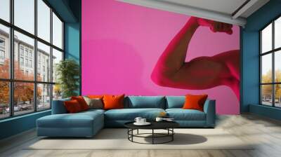 Strong male arm shows biceps. Neon led pink light. Wall mural