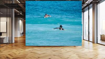 White man and black woman surfers swim on line up. Back view. Lifestule. Wall mural