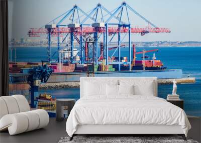 Port cargo crane loads a container onto a cargo ship Wall mural