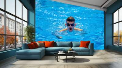 Fit swimmer training in the swimming pool. An overhead view of a man diving into a pool, forming an arrow shape and leaving a trail behind him. Professional male swimmer inside swimming pool. Young Wall mural