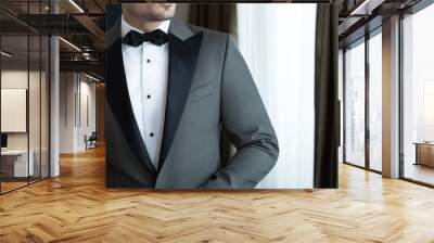 Man model in expensive custom tailored tuxedo, suit standing and posing indoors Wall mural