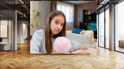 Beautiful little girl drawing funny at the table in her living room. Selective focus. Wall mural