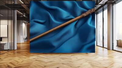 Elegant carved magic wand resting on blue silk fabric Wall mural