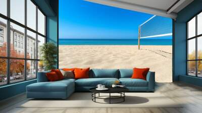 Volleyball net standing on empty beach under blue sky Wall mural