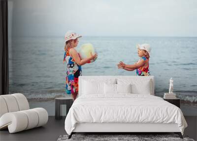 Two adorable sisters playing and having fun on the beach. Childhood, vacation, joy, happiness, frienship concept Wall mural