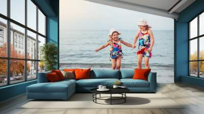 Two joyful happy girls play together on the sea beach, have fun smile. Childhood, vacation concept Wall mural