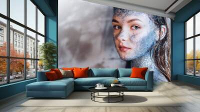 Young beautiful girl in fantastic creative makeup with rhinestone, dark background. Art beautiful girl model with cosmic make-up on face and body blue and silver skin color  Wall mural