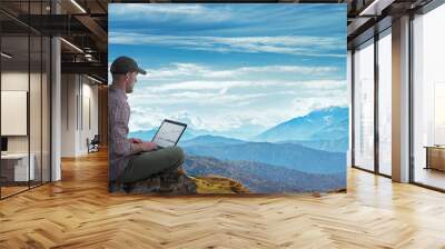 man working remotely outdoors with laptop Wall mural