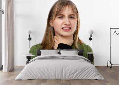 Portrait of fourteen year old girl shouting and suffocate because painful strangle isolated on white background. Blondy teenager in green clothes posing in studio. Asphyxiate and suicide concept. Wall mural