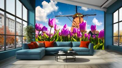 The famous Dutch windmills among blooming pink tulip flowers Wall mural