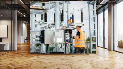 adult electrical engineer inspect the electrical systems at the equipment control cabinet. installat Wall mural