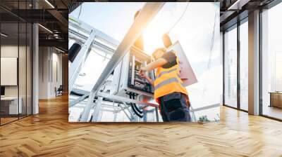 Adult electrical engineer inspect the electrical systems at the equipment control cabinet. Installation of modern electrical station Wall mural