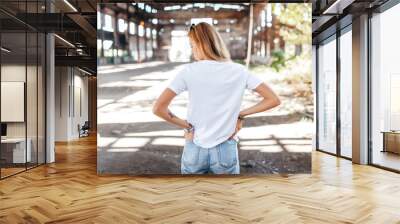 Girl wearing white t-shirt, glasses and leather jacket posing against street , urban clothing style. Street photography Wall mural