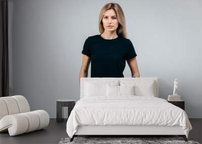 Stylish blonde girl wearing black t-shirt posing in studio Wall mural