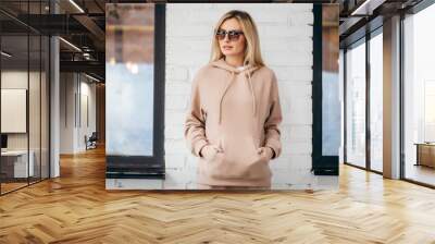 Young woman in glasses and hoodie Wall mural