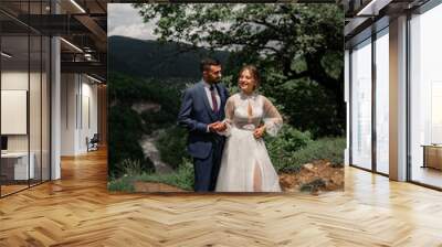 a beautiful couple of newlyweds in a wedding ceremony in the mountains Wall mural