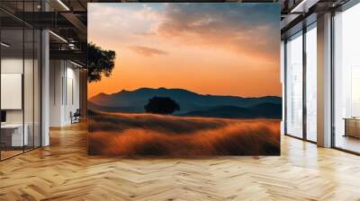 A tree stands in a field with a beautiful sunset in the background Wall mural