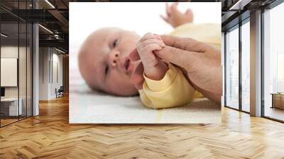 Baby boy holding father's hand Wall mural