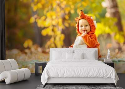 Cute baby boy dressed in fox costume in autumn park Wall mural