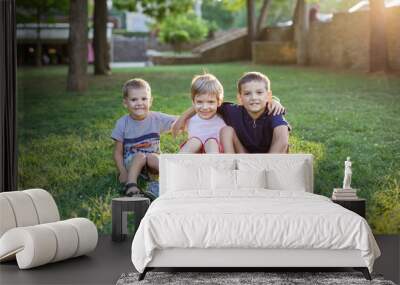 Three happy young boys in summer park Wall mural