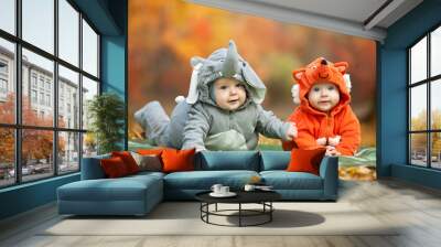 Two baby boys dressed in animal costumes in autumn park Wall mural