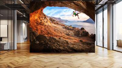 Young man lead climbing in cave before sunset Wall mural