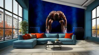 Muscular man working out with barbell Wall mural