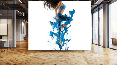 Sporty woman with jeans jumping on blue paint background Wall mural