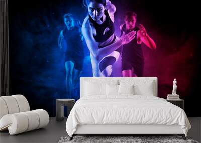 Sporty young woman and men running Wall mural