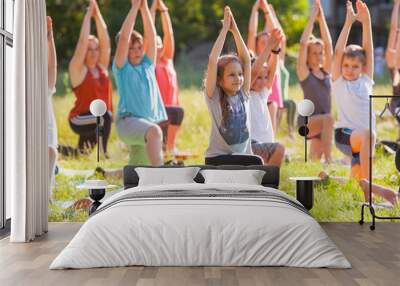 children do yoga with an outdoor trainer. Wall mural