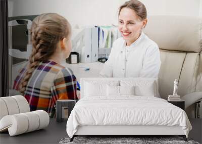 doctor interviews little girl before being examined in ophthalmologist's office. Wall mural