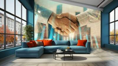 Double exposure of financial graph on cityscape background with two businessman handshake. Concept of stock market deal Wall mural