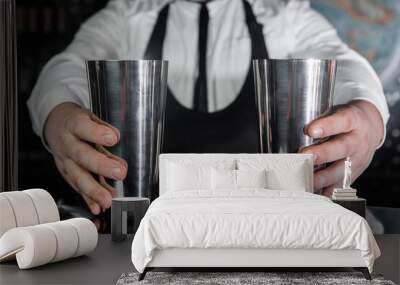 Hands of a professional bartender hold 2 tools for mixing and preparing alcoholic cocktail shakers, close-up Wall mural