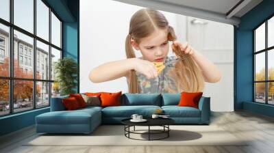 little girl cutting hair to herself with scissors Wall mural